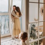 A joyful family moment with parents and children cuddling indoors during the day.